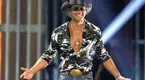 Tim-Mcgraw-Performing-On-Stage-Showing-Chest.webp