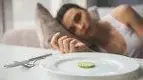 Female-Staring-At-Plate-With-Single-Slice-Cucumber.webp