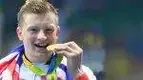 old-Medal-Swimmer-Adam-Peaty-Biting-His-Gold-Medal.webp