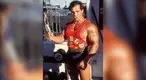 nd-Franco-Columbu-posing-in-front-of-dumbbell-rack.webp