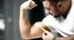 -Measuring-His-Biceps-Growth-With-A-Measuring-Tape.webp