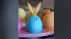 Blue-Easter-egg-with-bunny-ears-and-a-smiley-face.webp