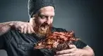 Hungry-Bearded-Man-Eating-A-Bucket-Of-Bacon.webp