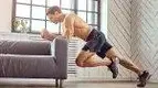 less-Man-Exercising-In-Living-Room-Against-A-Couch.webp