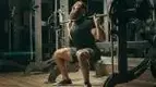 Bearded-Man-Struggling-With-Squat-At-Smith-Machine.webp