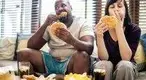 Heavy-Interracial-Couple-Eating-Junk-Food-On-Couch.webp