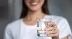 Woman-Holding-Out-A-Glass-Of-Water.webp