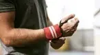 Man working out and avoiding wrist injuries using a wrist strap