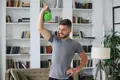 A man does kettlebell workouts at home