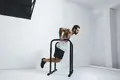 A man does a dip using basic gym equipment