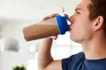 Man drinking whey protein shake after workout.