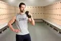 Man drinking protein in locker room after workout.