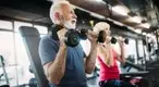 Elder man working out with dumbbells in the gym