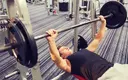 Strong man doing barbell chest press in the gym.