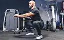 Older man doing bodyweight squats in the gym