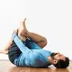 lying on floor pulling leg into chest hamstring stretch