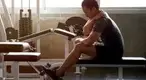 Young male working out in the gym with a shoulder injury and recovering with the muscle flossing technique due to muscle soreness