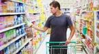 Young male looking at food labels while shopping for food