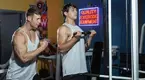 Michael Wittig teaching a teenager how use the cable machine with cable curls