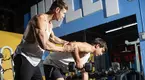 Michael Wittig teaching a teenager how to perform dumbbell rows