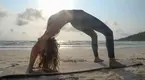 yoga instructor performing a backbend wheel pose on the beach