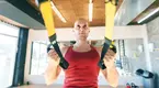 Focused-Bald-Man-Doing-TRX-Recline-Row and TRX accessory exercises for his suspension trainer exercises