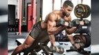 Man working out with bicep curls variation Dumbbell Spider Curl biceps exercise