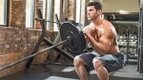 Muscular man performing a landmine training with a landmine squat exercise