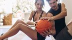 Fit couple working out their oblique muscles with medicine ball twist