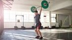 Fit Man in the gym performing a barbell clean and Push Press exercise