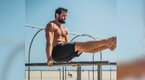 Aaron Rodgers performing left lift dips outdoors on a beach