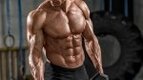 Bodybuilder with a six pack holding dumbbells