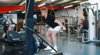 Young muscular blonde man demonstrating ski erg workouts