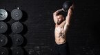 Muscular man performing power training exercises to build power with a medball slam