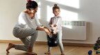 A mom and daughter lifting a kettlebell together for a workout plan for moms