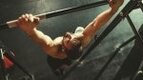 Muscular CrossFit athlete performing bar muscle ups for the CrossFit Open 25.2 Workout