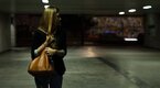 Young female alone in a dark parking lot