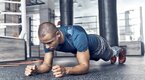 Boxer working out his core muscles by doing a plank exercise in a boxing gym