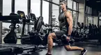 Young-Muscular-Man-Doing-Lunges-In-Dark-Gym.webp