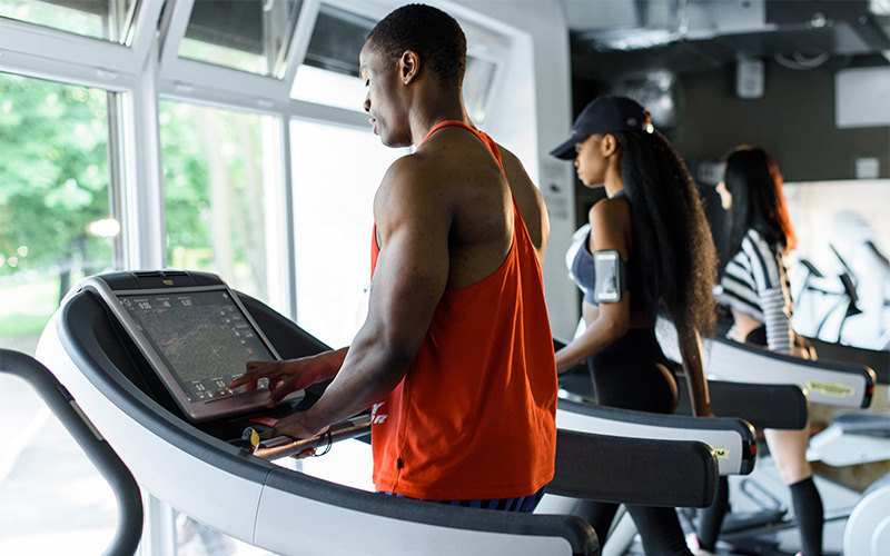 Muscular African American man doing cardio on the treadmill