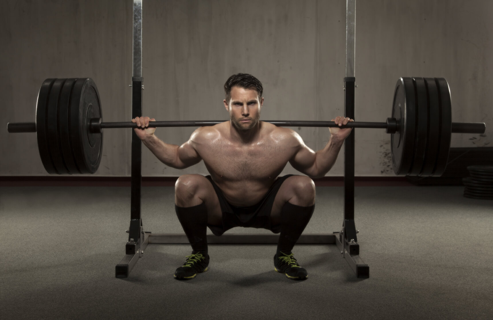 Powerlifter sits in the bottom of a squat with 405 on the bar.